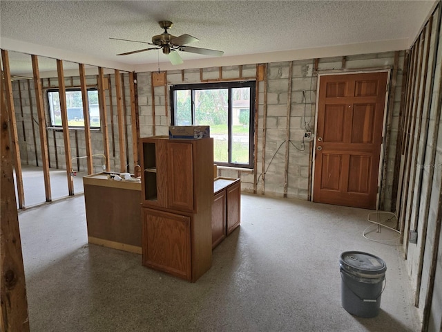 interior space featuring ceiling fan and a textured ceiling