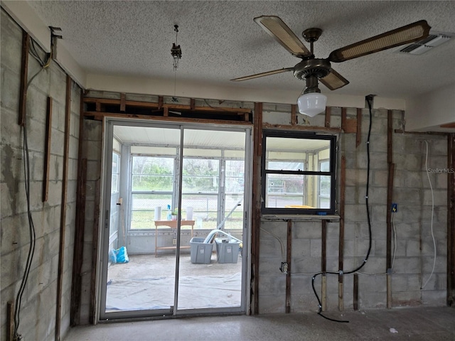 misc room featuring ceiling fan and a textured ceiling