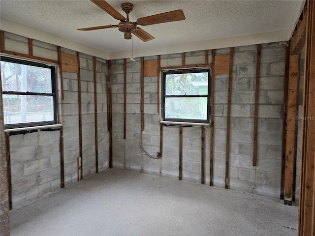 basement with ceiling fan and a textured ceiling