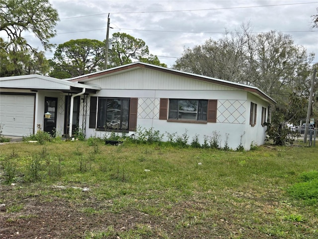 single story home featuring a garage and a front lawn