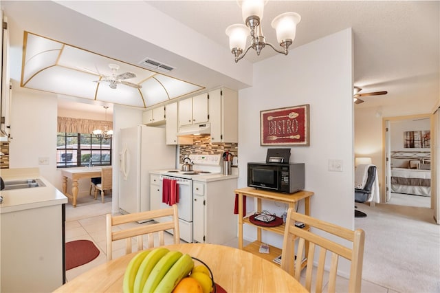 kitchen with backsplash, pendant lighting, white cabinets, and white appliances