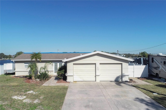 ranch-style home featuring a garage and a front lawn