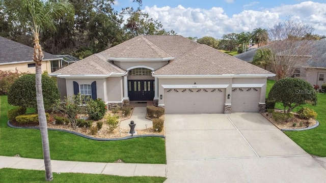 ranch-style house featuring a front yard, concrete driveway, an attached garage, and stucco siding