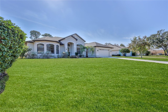 mediterranean / spanish-style home featuring a garage and a front lawn