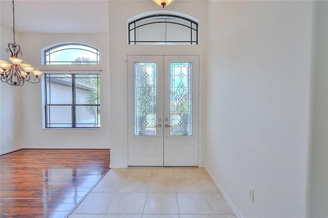 entrance foyer featuring a notable chandelier, light wood-type flooring, and french doors