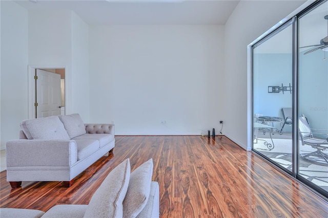 living room featuring ceiling fan and dark hardwood / wood-style flooring