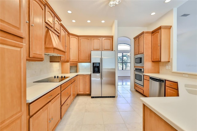 kitchen featuring sink, decorative backsplash, light tile patterned floors, stainless steel appliances, and custom range hood