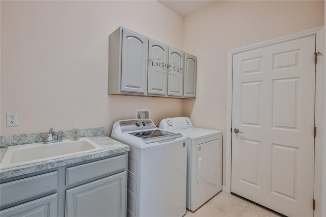 washroom with cabinets, sink, and washer and clothes dryer