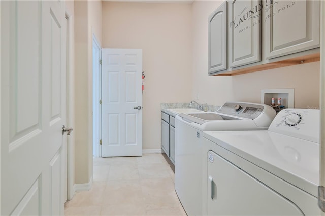 washroom with cabinets, light tile patterned flooring, sink, and washer and clothes dryer