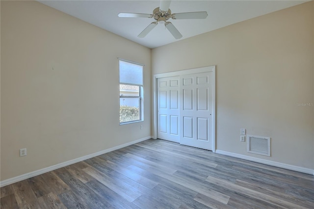 unfurnished bedroom with ceiling fan, hardwood / wood-style floors, and a closet