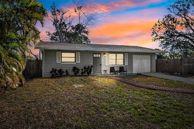 ranch-style house with a garage and a lawn