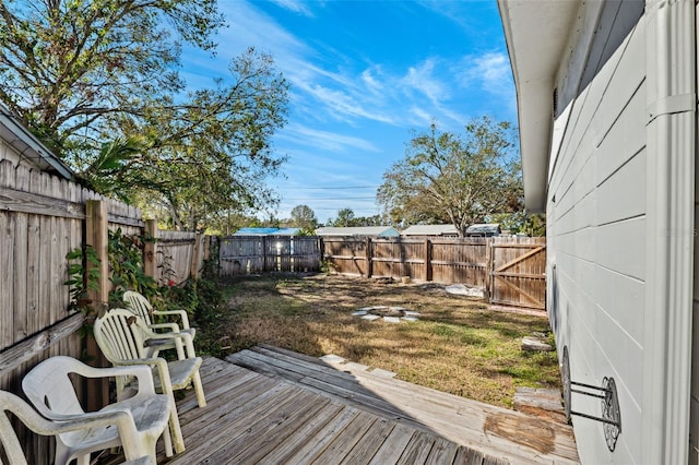 deck featuring a fenced backyard and a lawn