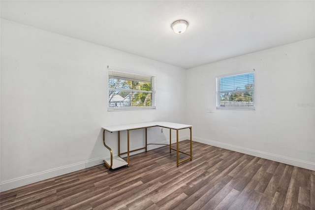 home office featuring plenty of natural light, baseboards, and dark wood finished floors