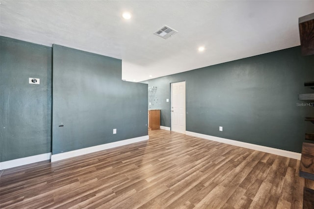 empty room featuring baseboards, visible vents, wood finished floors, and recessed lighting