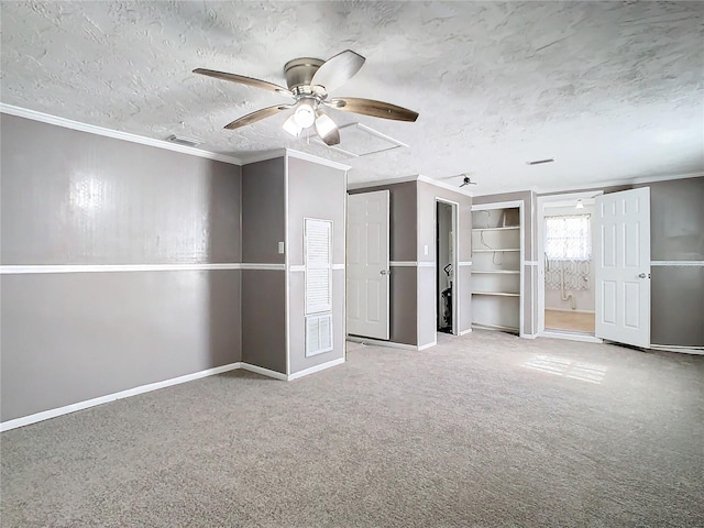 unfurnished bedroom featuring ceiling fan, crown molding, carpet floors, and a textured ceiling