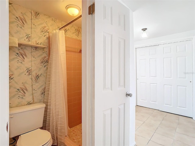 bathroom featuring toilet, tile patterned floors, and a shower with curtain