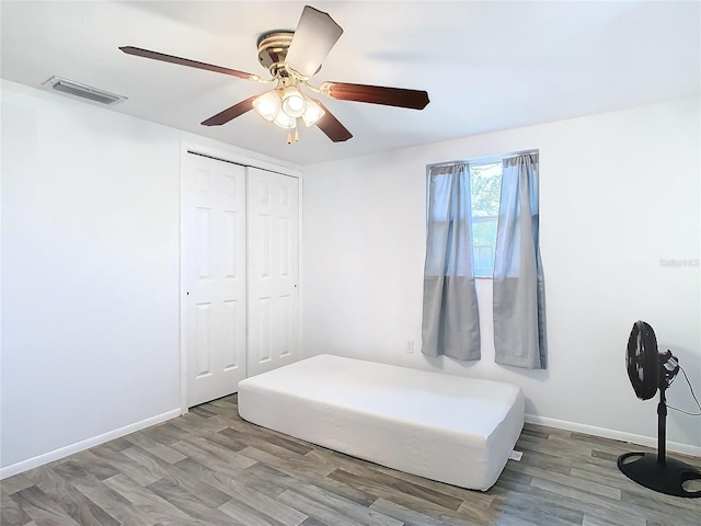 unfurnished bedroom with a closet, ceiling fan, and light hardwood / wood-style flooring