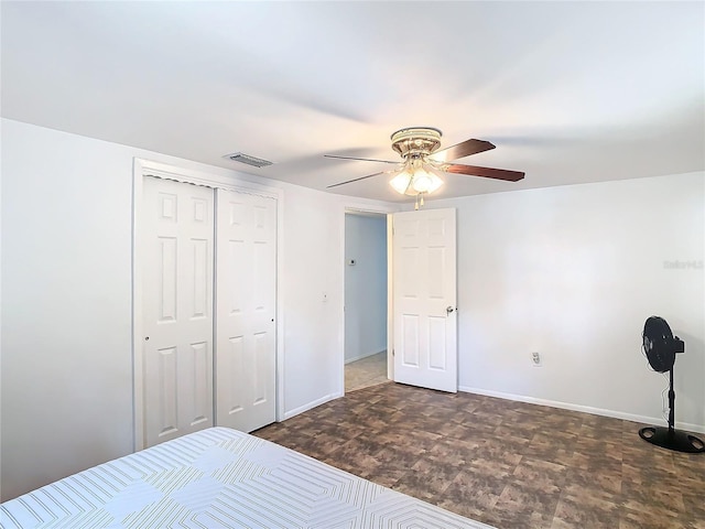 unfurnished bedroom with ceiling fan and a closet