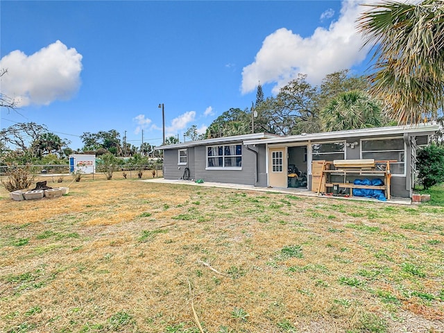 back of property with a lawn and a patio area