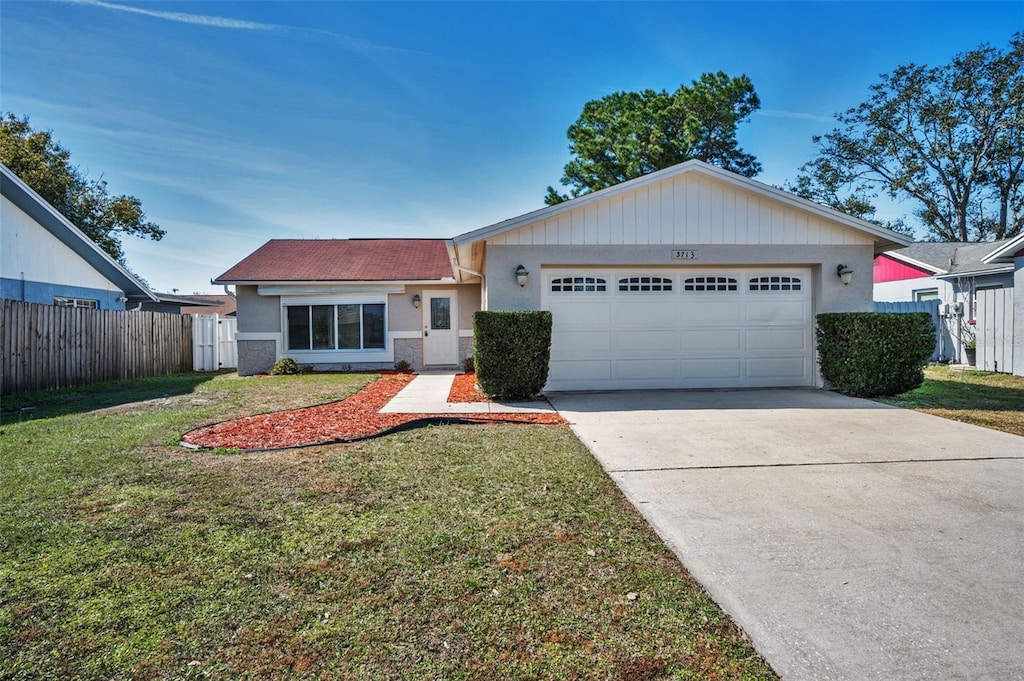 single story home with a garage and a front lawn