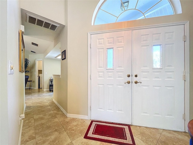 foyer featuring visible vents, baseboards, and light tile patterned flooring