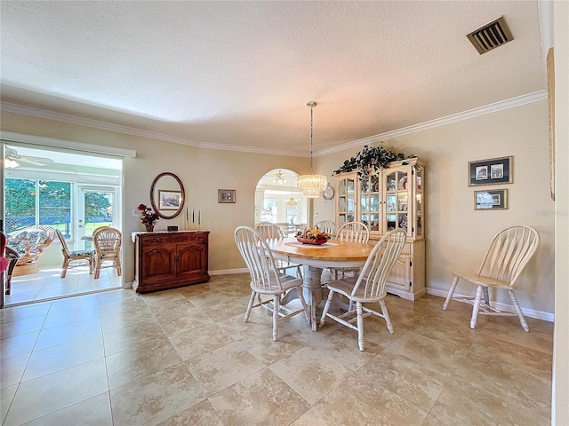 dining space with arched walkways, ornamental molding, a textured ceiling, and visible vents