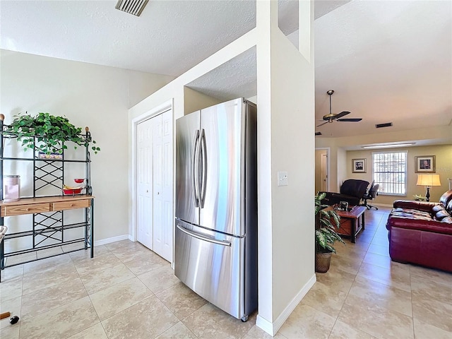 kitchen with visible vents, freestanding refrigerator, ceiling fan, a textured ceiling, and baseboards