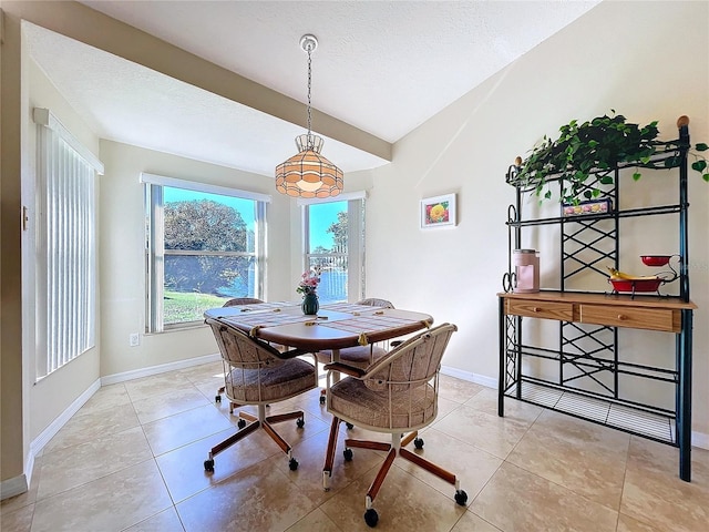 dining space featuring a textured ceiling, tile patterned flooring, and baseboards