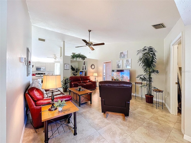 living area featuring visible vents, vaulted ceiling, baseboards, and ceiling fan