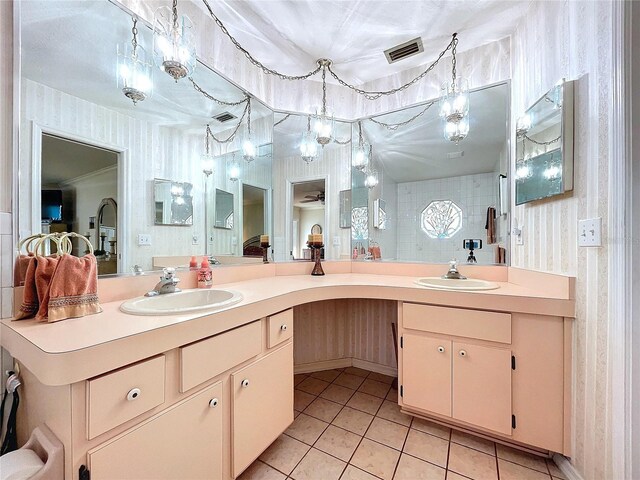 full bath featuring double vanity, tile patterned floors, a sink, and wallpapered walls