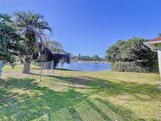 view of yard featuring a water view and fence