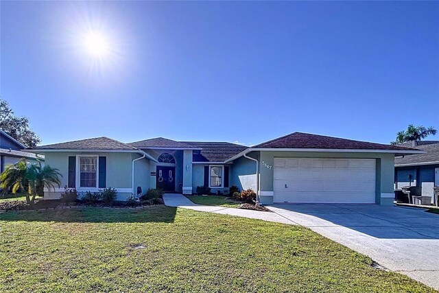 ranch-style house featuring driveway, a garage, a front lawn, and stucco siding