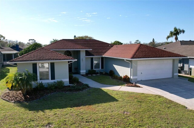 ranch-style home featuring a garage, a front lawn, concrete driveway, and stucco siding