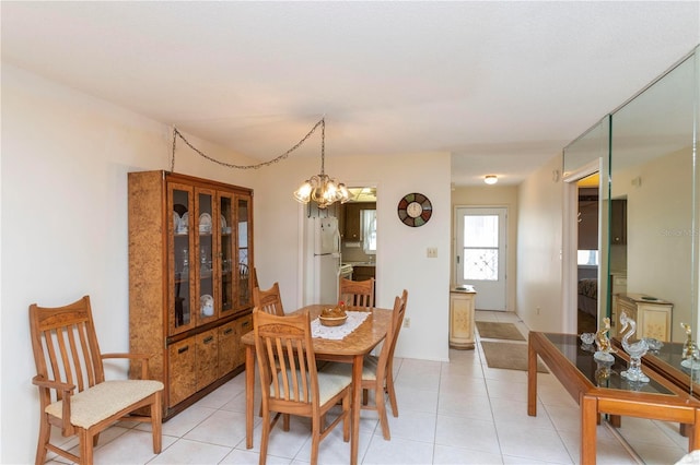 dining area with light tile patterned floors and a chandelier