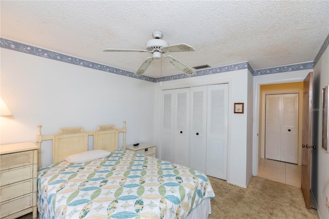 carpeted bedroom with ceiling fan, a textured ceiling, and a closet