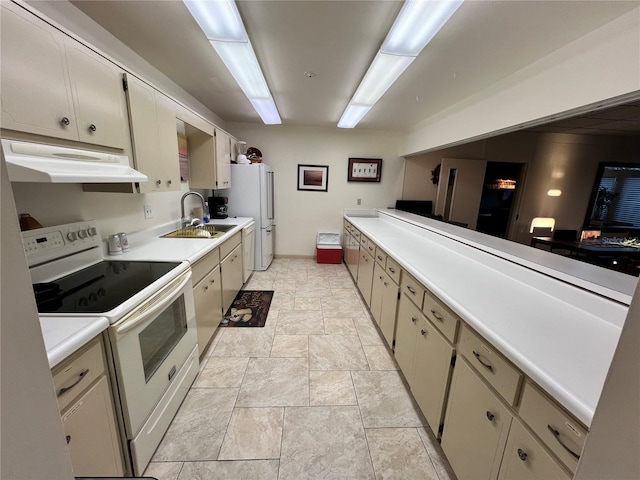 kitchen featuring white appliances, cream cabinets, and sink