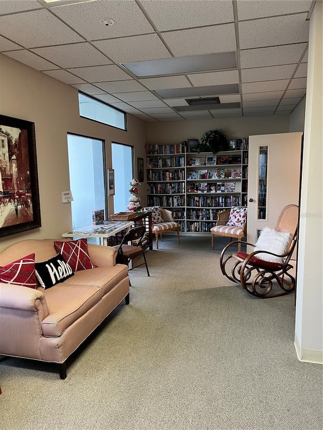 carpeted living room featuring a paneled ceiling