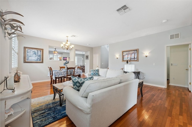 18819 Sunterra Dr, Land O Lakes, FL 34638 - living room with a chandelier, hardwood / wood-style flooring, and baseboards