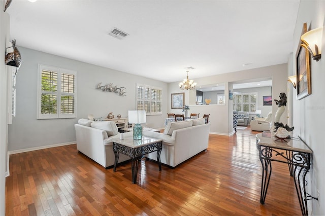18819 Sunterra Dr, Land O Lakes, FL 34638 - living room featuring healthy amount of natural light, a chandelier, and hardwood / wood-style floors