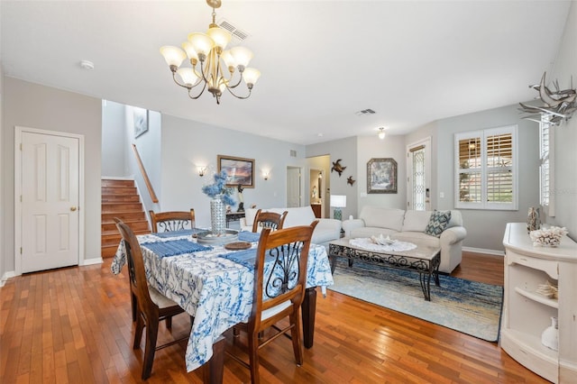 18819 Sunterra Dr, Land O Lakes, FL 34638 - dining room with stairs, a chandelier, hardwood / wood-style floors, and baseboards