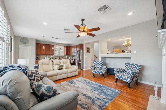 18819 Sunterra Dr, Land O Lakes, FL 34638 - living area featuring light wood-style flooring, a ceiling fan, recessed lighting, baseboards, and a chandelier