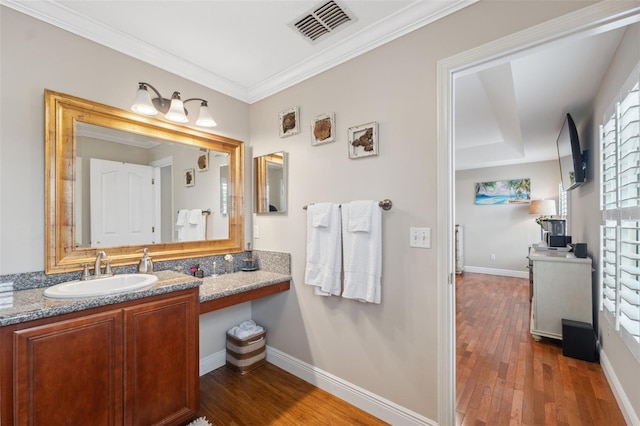 18819 Sunterra Dr, Land O Lakes, FL 34638 - bathroom featuring wood finished floors, vanity, crown molding, and baseboards
