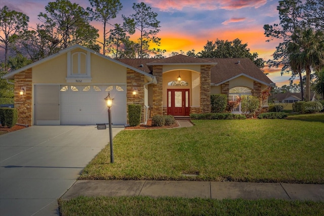 view of front of home featuring a garage, a yard, and french doors