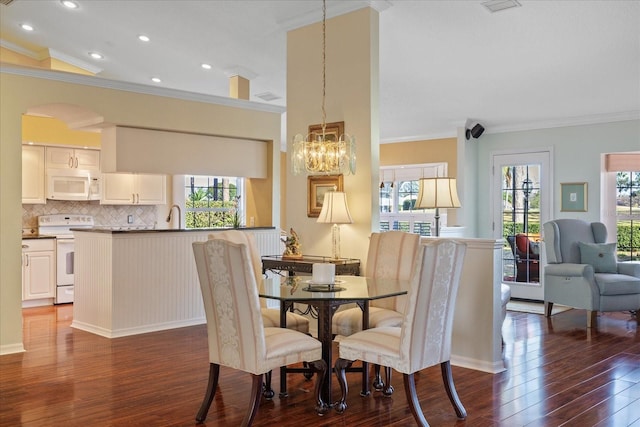 dining room featuring ornamental molding, dark hardwood / wood-style floors, and a chandelier