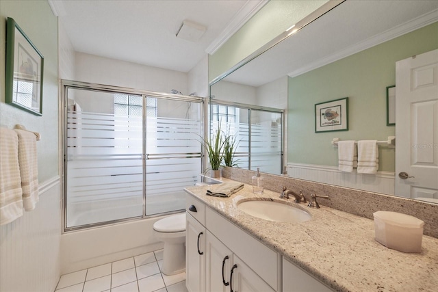 full bathroom with toilet, crown molding, shower / bath combination with glass door, vanity, and tile patterned flooring