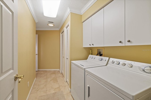 laundry room with light tile patterned floors, crown molding, cabinets, and washing machine and clothes dryer