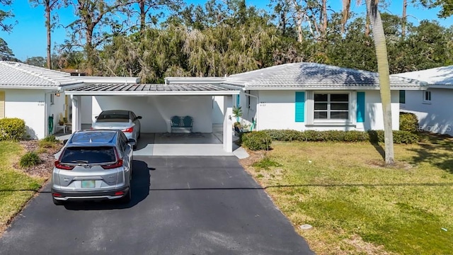 ranch-style home featuring a carport and a front lawn