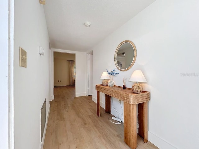 corridor with light hardwood / wood-style floors