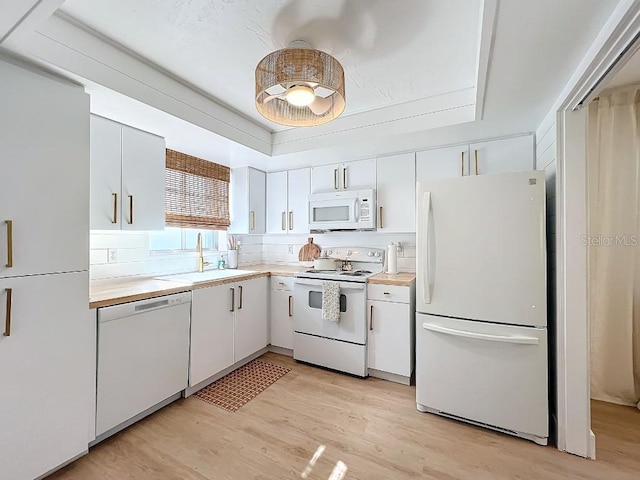 kitchen with light wood-type flooring, white appliances, sink, and white cabinets