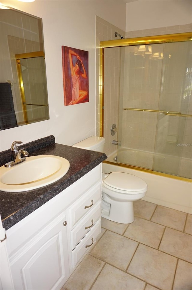 full bathroom with bath / shower combo with glass door, vanity, toilet, and tile patterned flooring